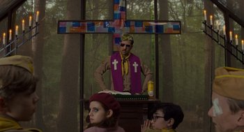 Movie still from “Moonrise Kingdom” (2012), directed by Wes Anderson – A man wearing a purple vest and a yellow hat; Medium shot, Low angle