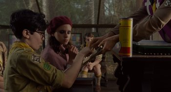 Movie still from “Moonrise Kingdom” (2012), directed by Wes Anderson – A girl scout sitting in front of a man holding a knife; Medium shot, Over the shoulder angle