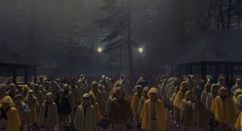 Movie still from “Moonrise Kingdom” (2012), directed by Wes Anderson – A large group of people wearing rain jackets; Extreme Wide shot, High angle
