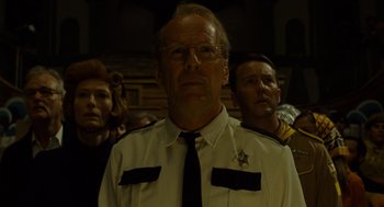 Movie still from “Moonrise Kingdom” (2012), directed by Wes Anderson – A group of people standing next to each other in a room; Close Up shot, Low angle