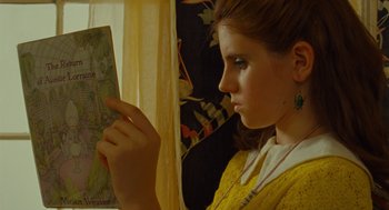 Movie still from “Moonrise Kingdom” (2012), directed by Wes Anderson – A young girl is looking at a map in front of a window; Close Up shot, Over the shoulder angle