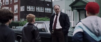 Movie still from “Mystic River” (2003), directed by Clint Eastwood – An older man and a young boy standing in front of a car; Medium shot, Over the shoulder angle