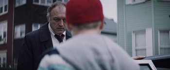 Movie still from “Mystic River” (2003), directed by Clint Eastwood – A man in a suit and a red hat looking at another man in a red hat; Close Up shot, Over the shoulder angle