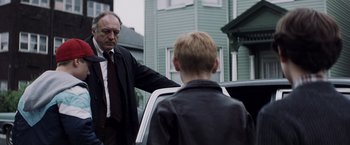 Movie still from “Mystic River” (2003), directed by Clint Eastwood – A man and a boy standing next to a car; Medium shot, Over the shoulder angle