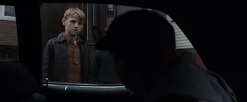 Movie still from “Mystic River” (2003), directed by Clint Eastwood – A young boy looking in the mirror of a car; Close Up shot, Over the shoulder angle