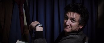 Movie still from “Mystic River” (2003), directed by Clint Eastwood – A man holding a watch in front of a blue curtain; Close Up shot, Over the shoulder angle