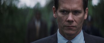 Movie still from “Mystic River” (2003), directed by Clint Eastwood – A person wearing a suit and tie; Close Up shot, Low angle