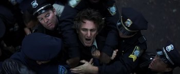 Movie still from “Mystic River” (2003), directed by Clint Eastwood – A group of police officers surrounding a man with his hands on his chest; Close Up shot, High angle
