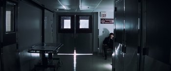 Movie still from “Mystic River” (2003), directed by Clint Eastwood – A man sitting in a room next to a door way; Wide shot, Low angle