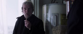 Movie still from “Mystic River” (2003), directed by Clint Eastwood – A man standing in front of a water heater; Close Up shot, Low angle