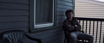 Movie still from “Mystic River” (2003), directed by Clint Eastwood – A man sitting on a chair in front of a window; Medium shot, Low angle