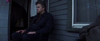 Movie still from “Mystic River” (2003), directed by Clint Eastwood – A man sitting on a chair in front of a window; Medium shot, Low angle
