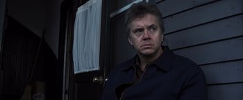 Movie still from “Mystic River” (2003), directed by Clint Eastwood – A man standing in front of a door looking at the camera; Close Up shot, Low angle