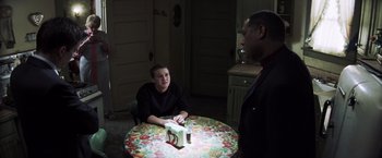 Movie still from “Mystic River” (2003), directed by Clint Eastwood – Two people sitting at a table with a candle; Medium shot, High angle