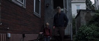 Movie still from “Mystic River” (2003), directed by Clint Eastwood – A man and a boy standing in front of a building; Wide shot, Low angle