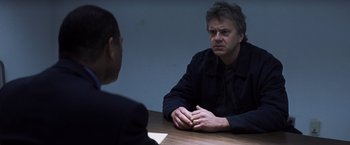 Movie still from “Mystic River” (2003), directed by Clint Eastwood – A man sitting in front of another man at a table; Close Up shot, Over the shoulder angle