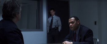 Movie still from “Mystic River” (2003), directed by Clint Eastwood – Two men standing in front of each other in a dark room; Medium shot, Over the shoulder angle