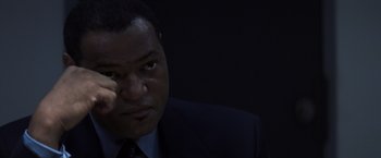 Movie still from “Mystic River” (2003), directed by Clint Eastwood – A man in a suit and tie looking at the camera; Close Up shot, Over the shoulder angle