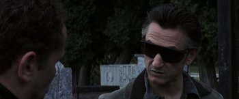 Movie still from “Mystic River” (2003), directed by Clint Eastwood – A person wearing a jacket and sunglasses; Close Up shot, Low angle