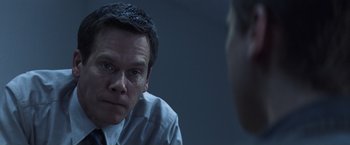 Movie still from “Mystic River” (2003), directed by Clint Eastwood – A man sitting in front of another man in front of a mirror; Close Up shot, Over the shoulder angle