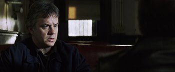 Movie still from “Mystic River” (2003), directed by Clint Eastwood – A person sitting in a room; Close Up shot, Over the shoulder angle
