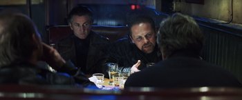 Movie still from “Mystic River” (2003), directed by Clint Eastwood – A group of men sitting at a table with drinks; Medium shot, Over the shoulder angle