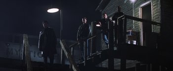 Movie still from “Mystic River” (2003), directed by Clint Eastwood – A group of people standing on a set of stairs; Wide shot, Low angle