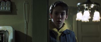 Movie still from “Mystic River” (2003), directed by Clint Eastwood – A young boy looking into a mirror in the dark; Close Up shot, Low angle