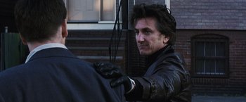 Movie still from “Mystic River” (2003), directed by Clint Eastwood – A man in a leather jacket holding a bow and arrow; Close Up shot, Over the shoulder angle