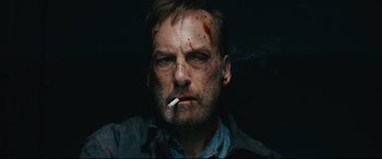 Movie still from “Nobody” (2021), directed by Ilya Naishuller – A person smoking a cigarette; Close Up shot, Low angle