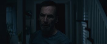 Movie still from “Nobody” (2021), directed by Ilya Naishuller – A person in a dark room; Close Up shot, Low angle