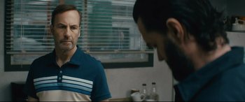 Movie still from “Nobody” (2021), directed by Ilya Naishuller – Two men are talking in a room; Close Up shot, Over the shoulder angle