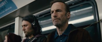 Movie still from “Nobody” (2021), directed by Ilya Naishuller – A man and a woman are standing in a train; Close Up shot, Low angle
