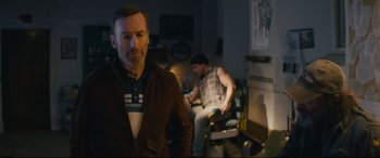 Movie still from “Nobody” (2021), directed by Ilya Naishuller – A man standing in front of another man sitting in a chair; Medium shot, Over the shoulder angle