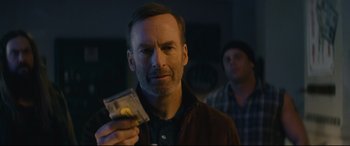 Movie still from “Nobody” (2021), directed by Ilya Naishuller – A man is holding a dollar bill in his hand; Close Up shot, Over the shoulder angle