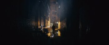 Movie still from “Nobody” (2021), directed by Ilya Naishuller – A person is walking in a dark alleyway at night; Extreme Wide shot, Low angle