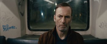 Movie still from “Nobody” (2021), directed by Ilya Naishuller – A person wearing a brown jacket; Close Up shot, Low angle