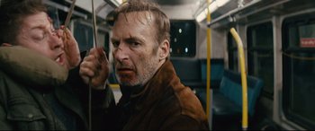 Movie still from “Nobody” (2021), directed by Ilya Naishuller – A person riding a bus; Close Up shot, Low angle