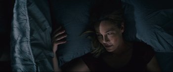 Movie still from “Nobody” (2021), directed by Ilya Naishuller – A woman laying in a bed with a pillow; Close Up shot, Overhead angle