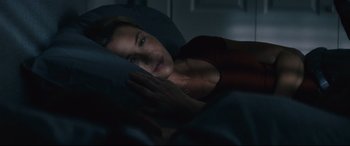 Movie still from “Nobody” (2021), directed by Ilya Naishuller – A woman laying in a bed looking at the camera; Close Up shot, Overhead angle