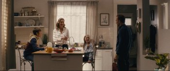 Movie still from “Nobody” (2021), directed by Ilya Naishuller – A woman standing in front of a kitchen counter with a child; Wide shot, Over the shoulder angle