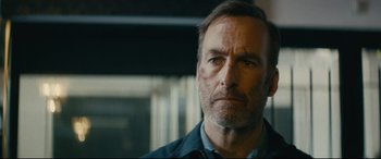 Movie still from “Nobody” (2021), directed by Ilya Naishuller – A person wearing a blue shirt; Close Up shot, Low angle