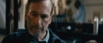 Movie still from “Nobody” (2021), directed by Ilya Naishuller – A person wearing a jacket; Close Up shot, Over the shoulder angle