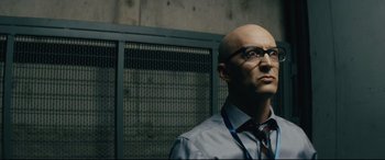 Movie still from “Nobody” (2021), directed by Ilya Naishuller – A bald man wearing glasses and a tie; Close Up shot, Low angle