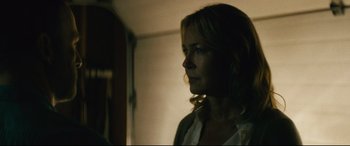 Movie still from “Nobody” (2021), directed by Ilya Naishuller – A woman standing in a room with her head turned to the side; Close Up shot, Over the shoulder angle