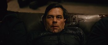 Movie still from “Nobody” (2021), directed by Ilya Naishuller – A person laying on a couch; Close Up shot, High angle