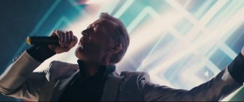 Movie still from “Nobody” (2021), directed by Ilya Naishuller – A person wearing a suit and tie; Close Up shot, Low angle