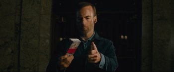 Movie still from “Nobody” (2021), directed by Ilya Naishuller – A man is holding a cigarette and looking at a cigarette pack; Close Up shot, Low angle