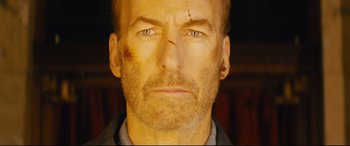 Movie still from “Nobody” (2021), directed by Ilya Naishuller – A man with a bruise on his face; Close Up shot, Low angle
