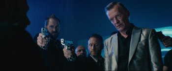Movie still from “Nobody” (2021), directed by Ilya Naishuller – A group of men standing next to each other holding guns; Medium shot, Low angle